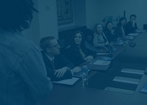 Elliott School student sitting at a conference table with a blue overlay