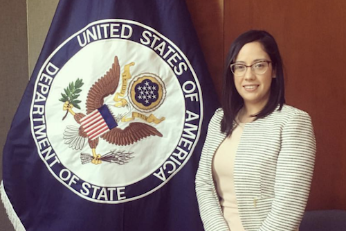 Daniela Negarez next to the US State Department flag
