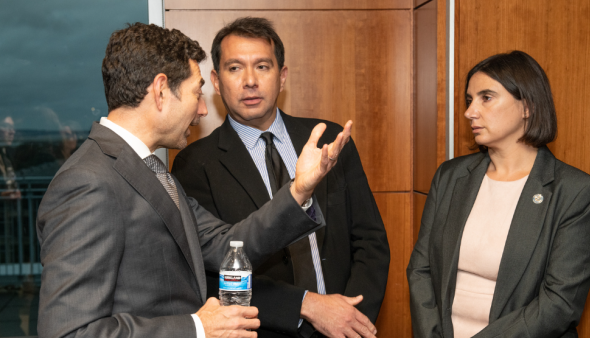 Tino Cuellar speaks with two people