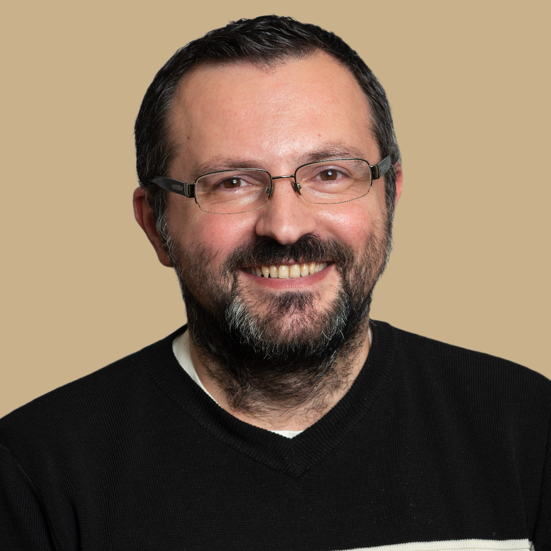 Andrei Tusa headshot on a beige background