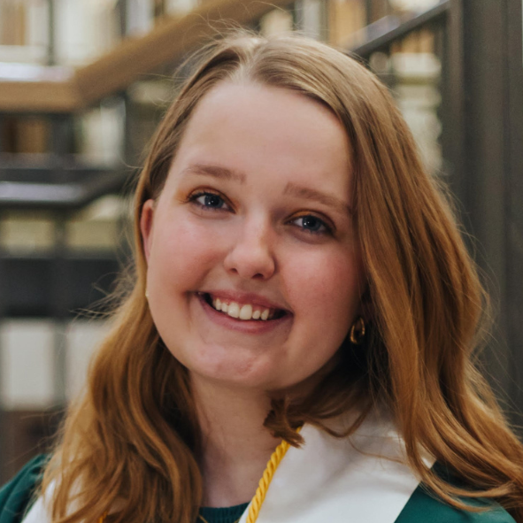 Olivia Dunn smiles. She is wearing graduation regalia.