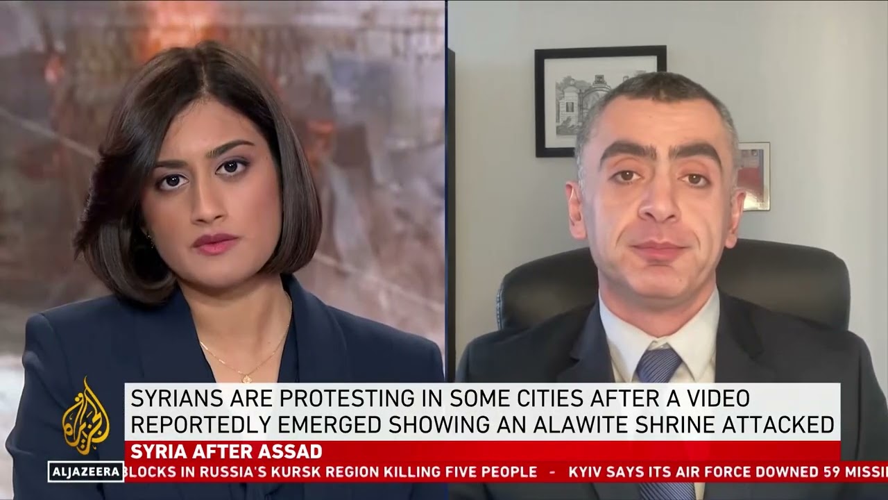 Sina Azodi sitting in office on interview with TRT. Interviewer to the left. 