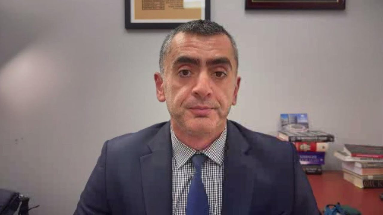 Sina Azodi sitting in office on interview with TRT.