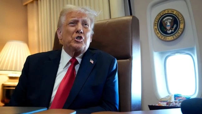 President Donald Trump speaks to reporters aboard Air Force One on Sunday, Feb. 9, 2025. (AP Photo/Ben Curtis)
