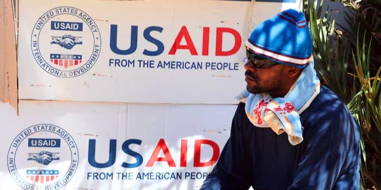 A refugee waits near boxes of USAID at the Tunisian refugee camp of Choucha near Ras Ajdir, Tunisia. PHOTO/Dominique Faget/AFP