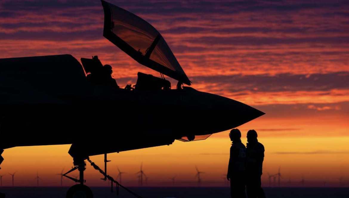 Two pilots standing in front of an aircraft.