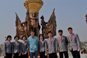 Photo of student Casey Robinson posing with others in front of a gold column surrounded by statues