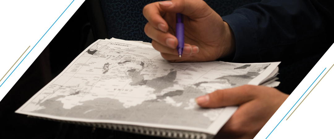 A student writes in country names on a map of Asia