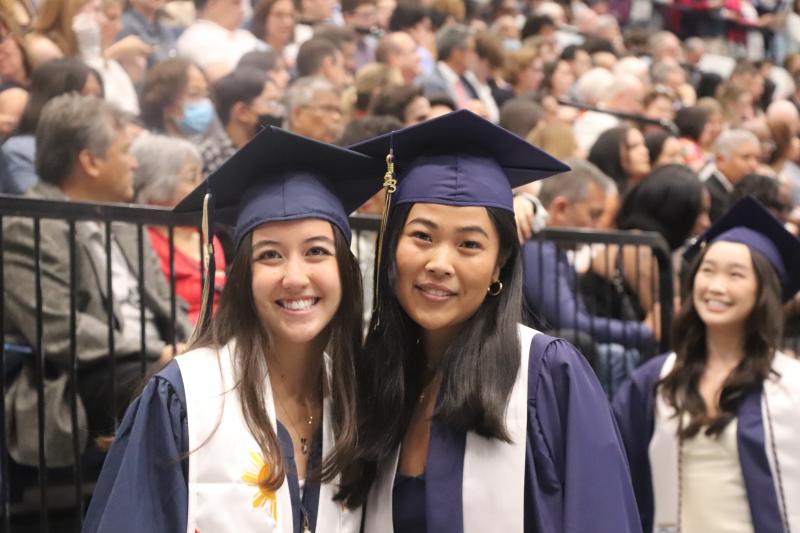 Two Elliott School students smile during graduation.