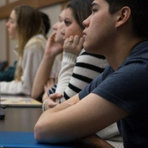 Students listen to a professor in a lecture hall