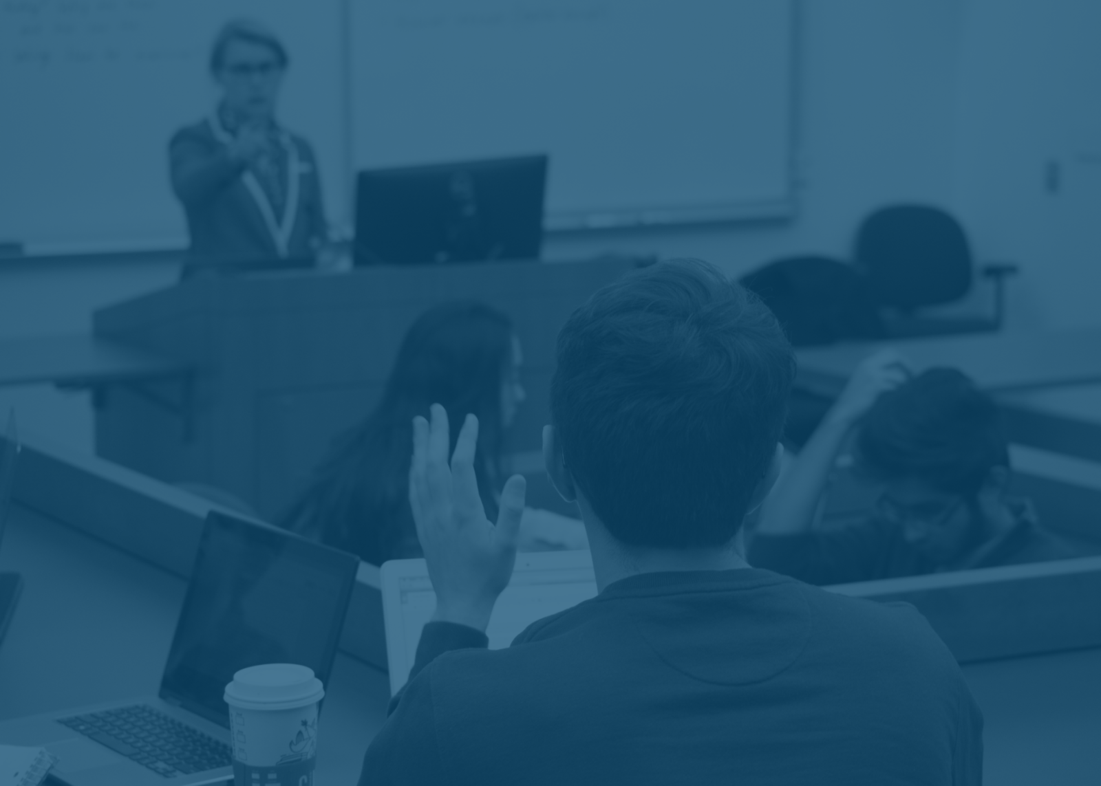 Student raising hand in lecture with light blue background