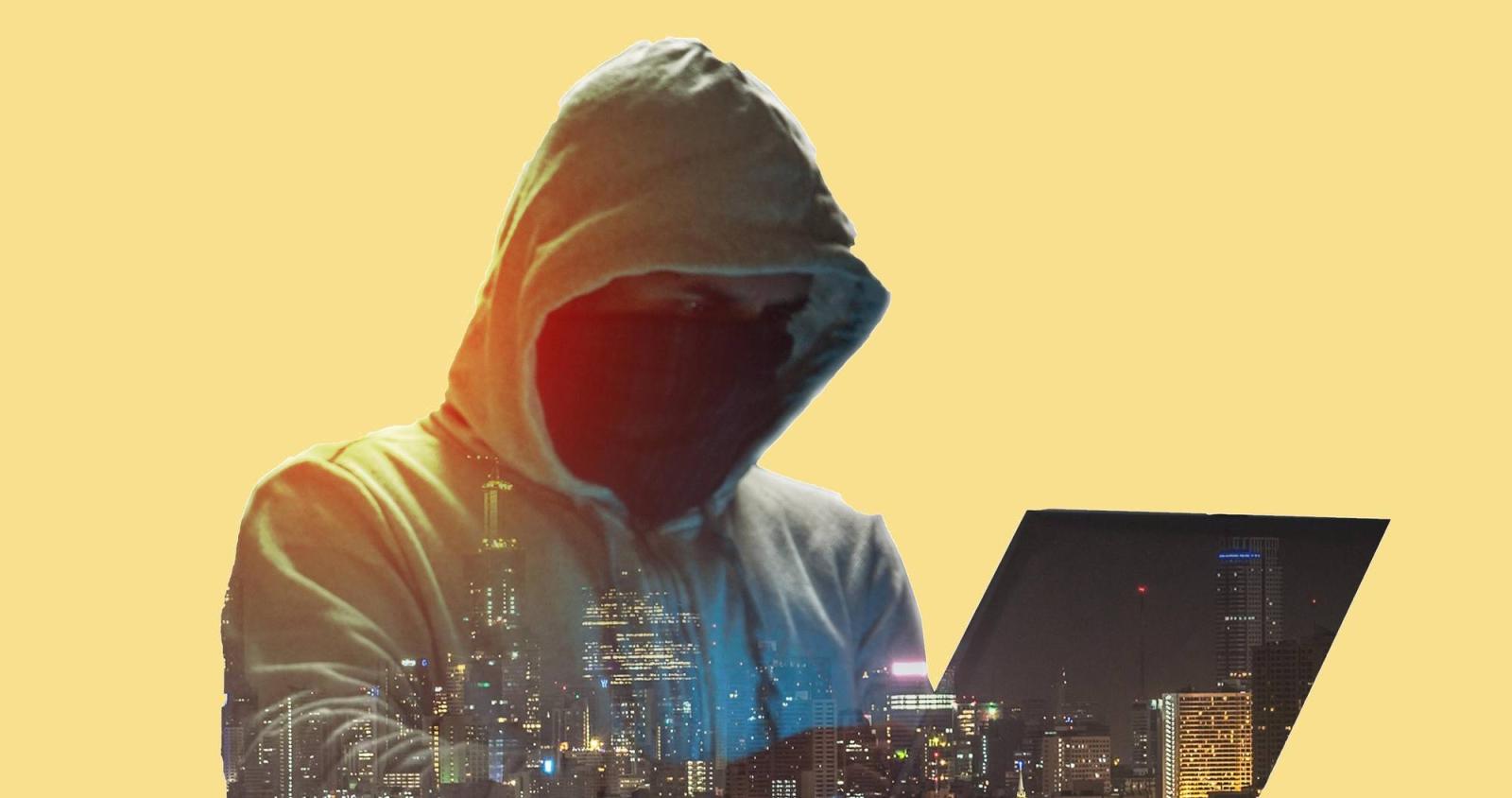 Hacker on laptop with hood over head