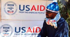 A refugee waits near boxes of USAID at the Tunisian refugee camp of Choucha near Ras Ajdir, Tunisia. PHOTO/Dominique Faget/AFP
